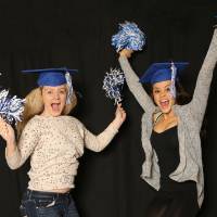 two friends jumping with pom poms